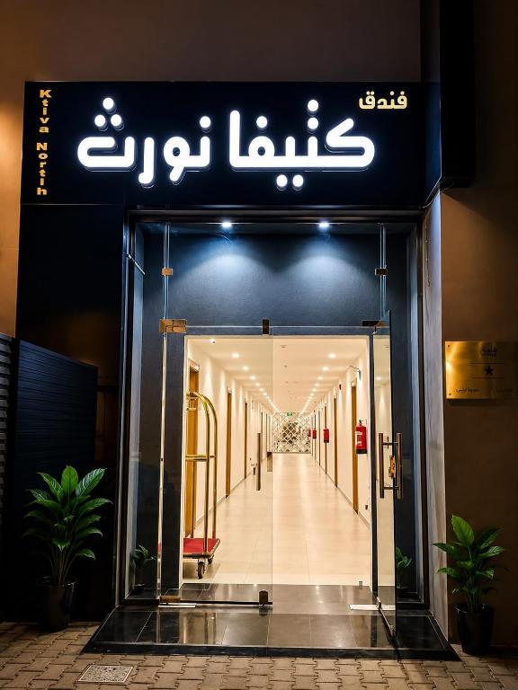 a building with a sign over the entrance to a hallway at فندق كتيفا نورث in Arar