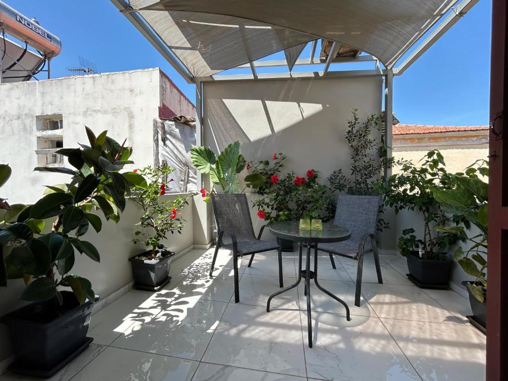 a patio with a table and chairs and potted plants at The Central Retreat 4 in Mytilene