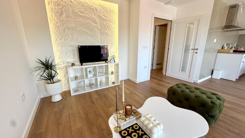 a living room with a television and a green chair at Nikola apartman in Arilje