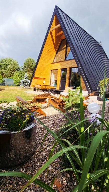 a small house with a black roof and some plants at Domki Żabiniec in Jedle