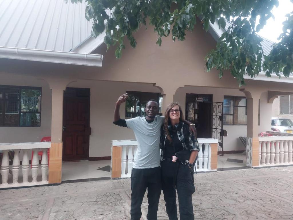 a man and a woman standing in front of a house at Amazon half london in Boma la Ngombe