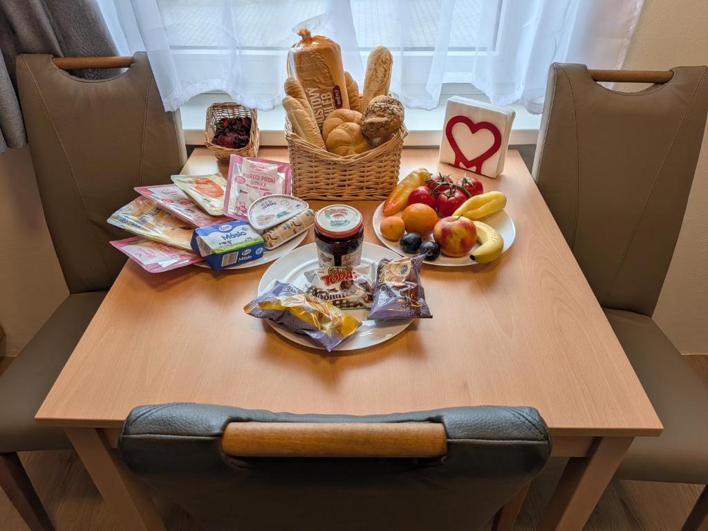 a table with a plate of food and a basket of bread at 386 Apartman in Písek
