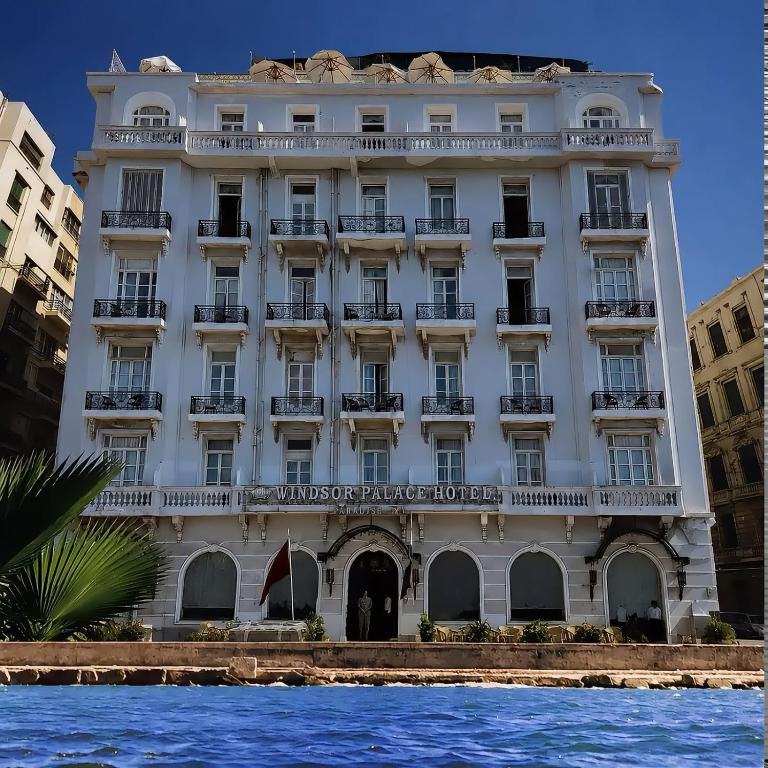 a large white building next to a body of water at Windsor Palace Luxury Heritage Hotel Since 1906 by Paradise Inn Group in Alexandria