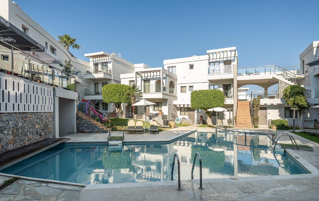 a swimming pool in front of some apartment buildings at Minos Village in Agia Marina Nea Kydonias