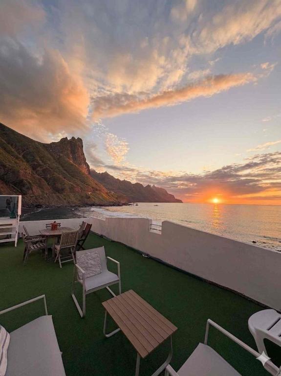 a balcony with a table and chairs and the ocean at Ocean front La Maresia Holiday 2 Apartments in Taganana