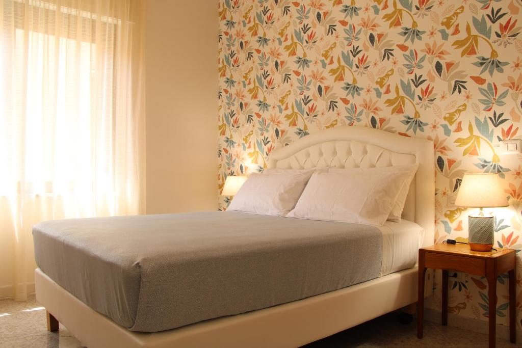a bedroom with a bed with a floral wallpaper at Guest House Scarlatti in Battipaglia