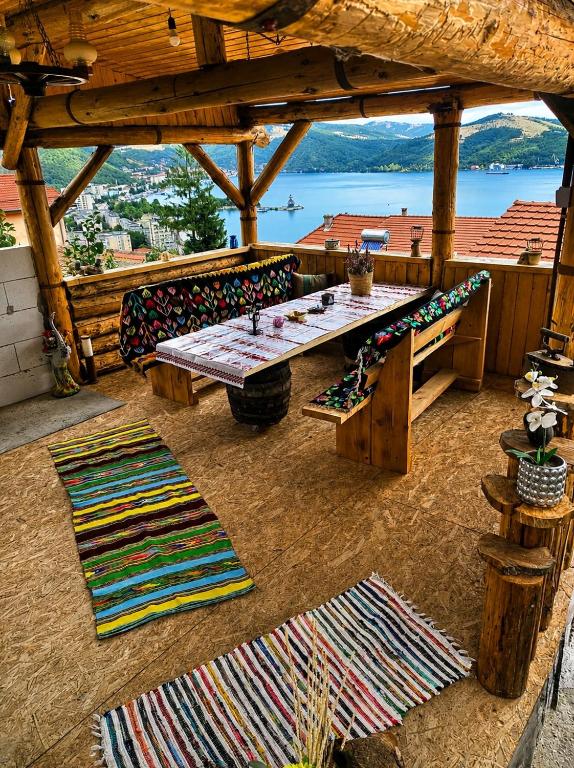 a wooden deck with a table and some rugs at Best view house in Orşova