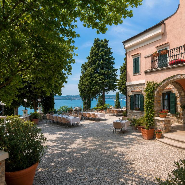 a patio with tables and chairs in front of a building at Villa Andor in Ankaran