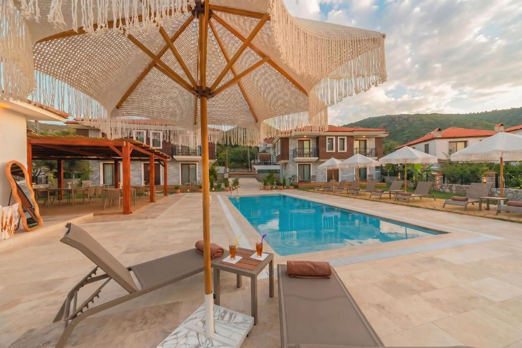 a patio with an umbrella and a swimming pool at Kiraz Vela Selimiye in Marmaris