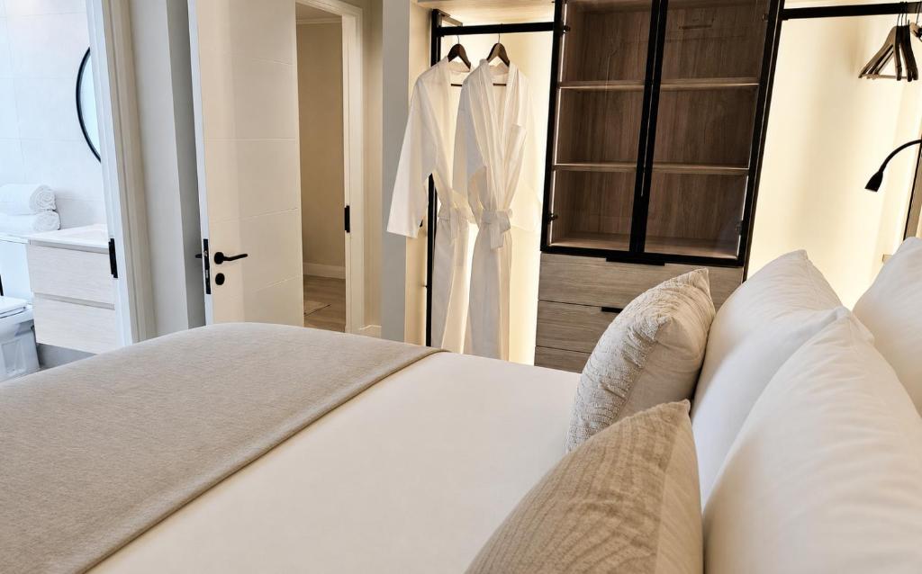 a bedroom with a white bed and a closet at LUUM by Norus in Santiago