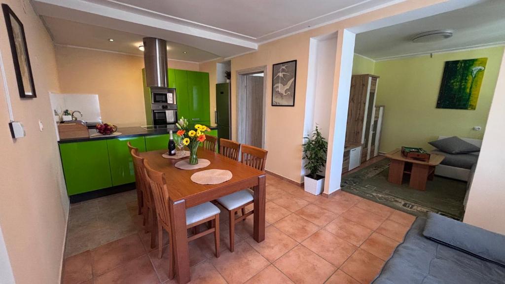 a kitchen and dining room with a wooden table and chairs at Apartma Rožman in Radenci