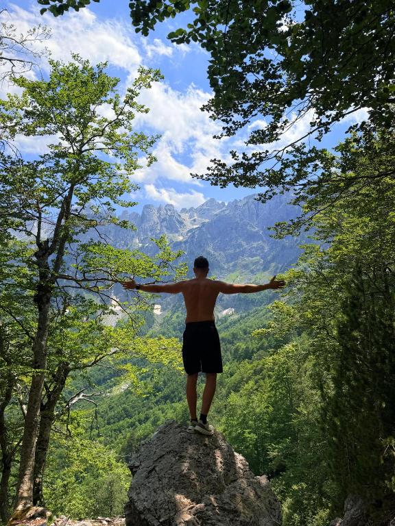 a man standing on top of a rock with his arms out at ILDO Guesthouse in Asim Zeneli