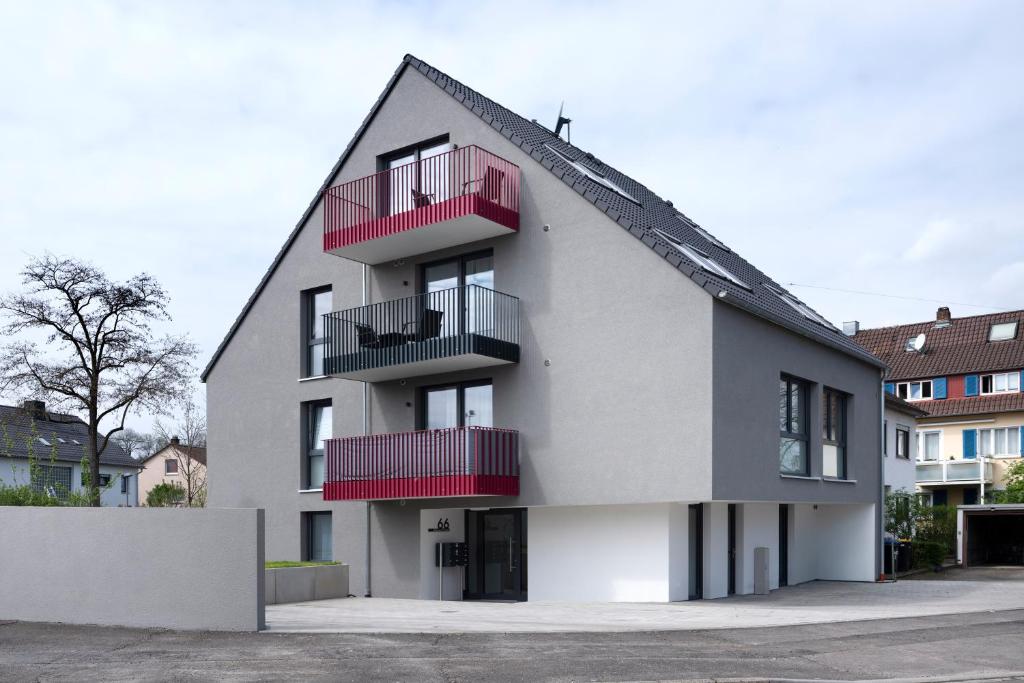 a white building with red balconies on it at Alleenstraße 66 in Wendlingen am Neckar