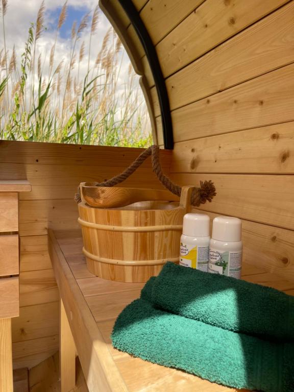 a wooden sauna with a green towel and a basket at Trentseeparadies in Plön