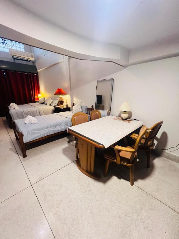 a room with a bed and a table and chairs at Baan Bangrak Home in Bang Rak