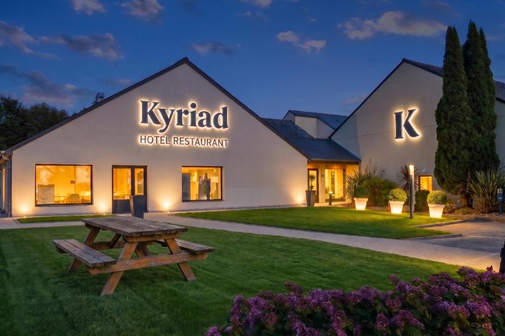a building with a picnic table in the yard at Kyriad Lannion-Perros-Guirec in Lannion
