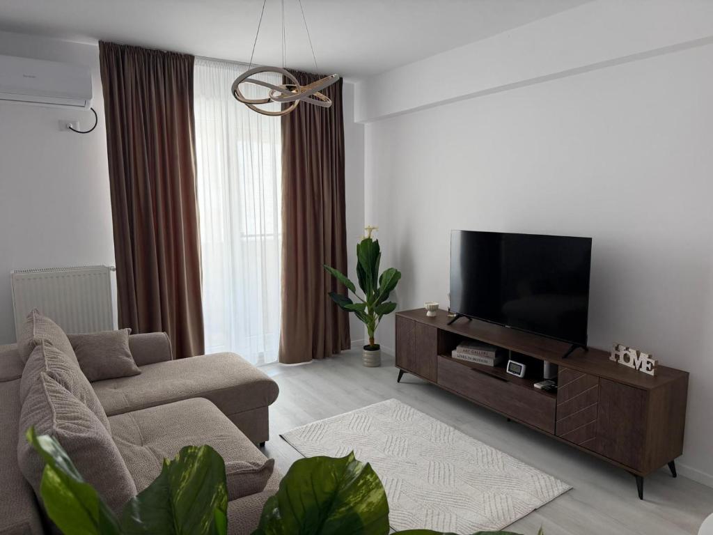 a living room with a couch and a flat screen tv at Elegant & cozy NeSt in Chiajna
