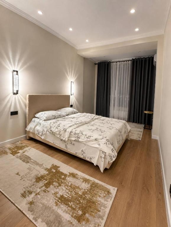 a bedroom with a bed and a large window at Lux Residence 3 in Osh