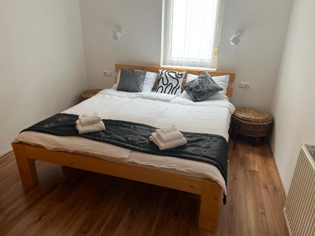 a bedroom with a large bed with two towels on it at Johanna Apartman in Harkány