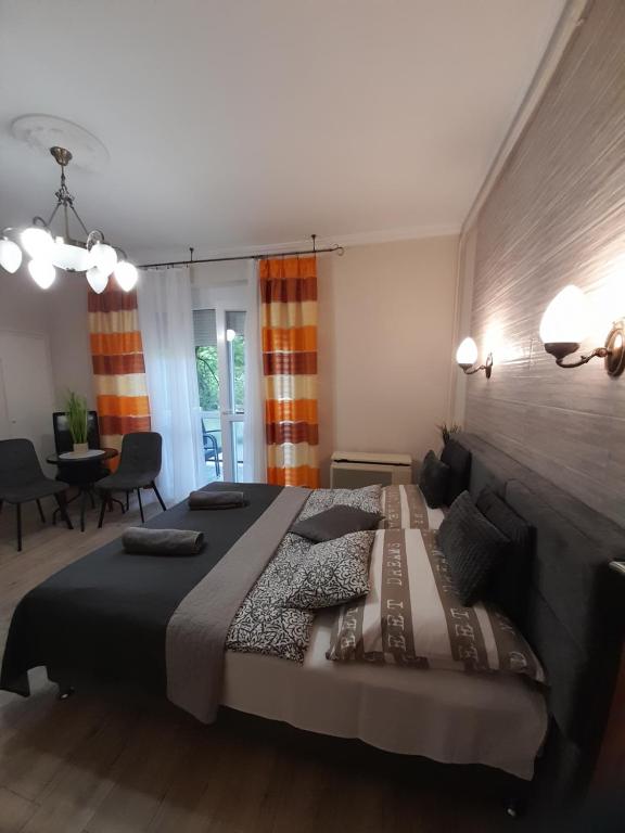 a bedroom with a large bed and a dining room at Zöld Sziget Apartmanlakás in Eger