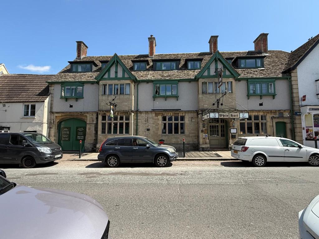 a large building with cars parked in front of it at White Hart Hotel in Cricklade
