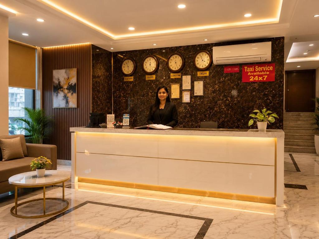 a woman standing at a counter in a hotel lobby at Hotel Aviora Plaza By Almati Group Near IGI Delhi Airport With - Free Airport Pickup in New Delhi