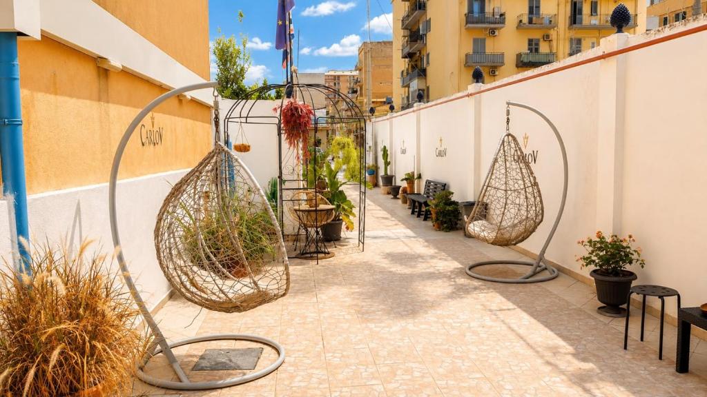 a patio with plants in baskets on the side of a building at Carlo FiVe in Porto Empedocle