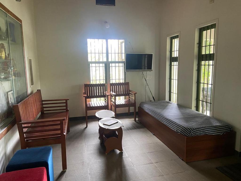 a room with a bed and a couch and chairs at SOLITUDE Riverside Holiday Home in Vallikunnu