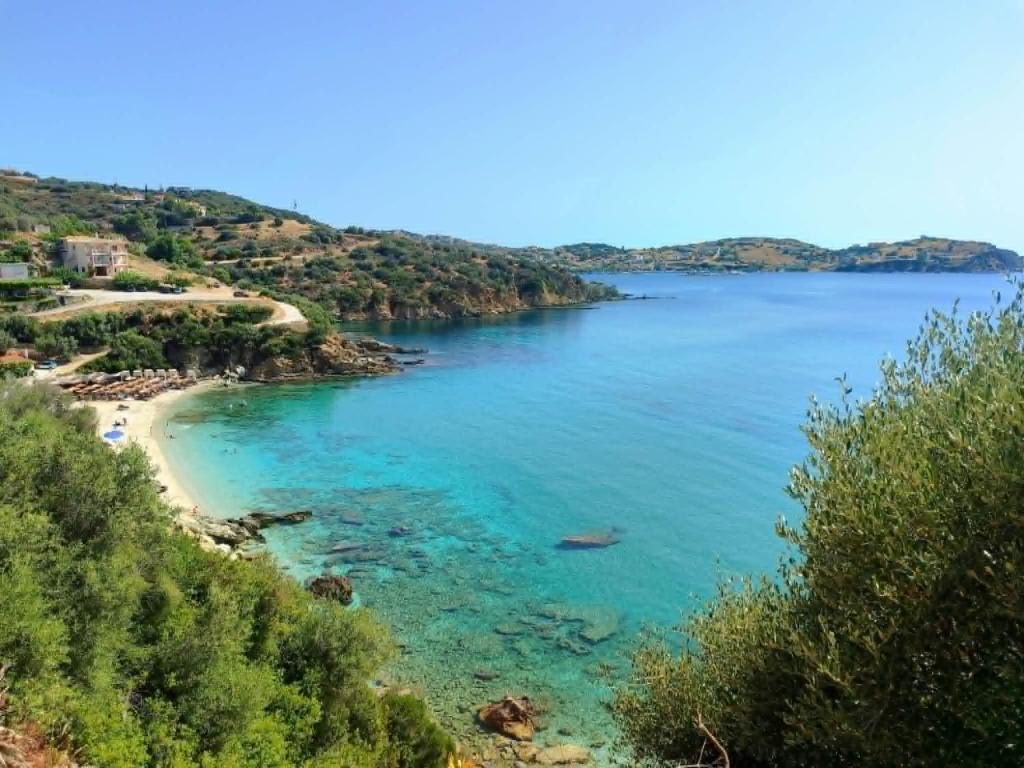 a view of a beach with blue water at Aegean Beachfront Apartments in Petriaí
