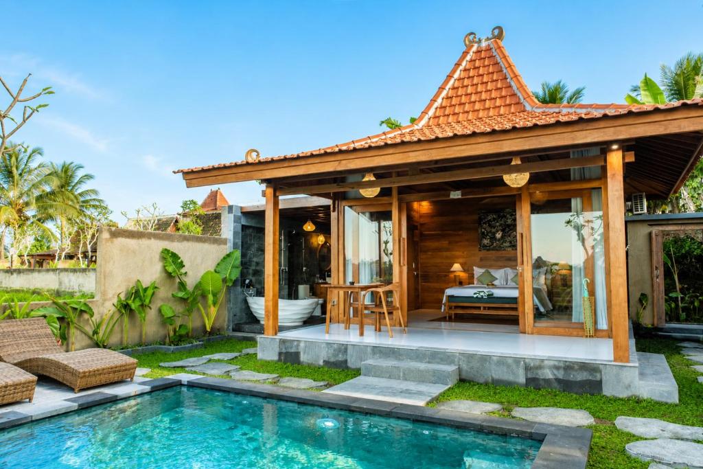 a villa with a pool and a guest house at Kubu Tama Villa in Tegalalang