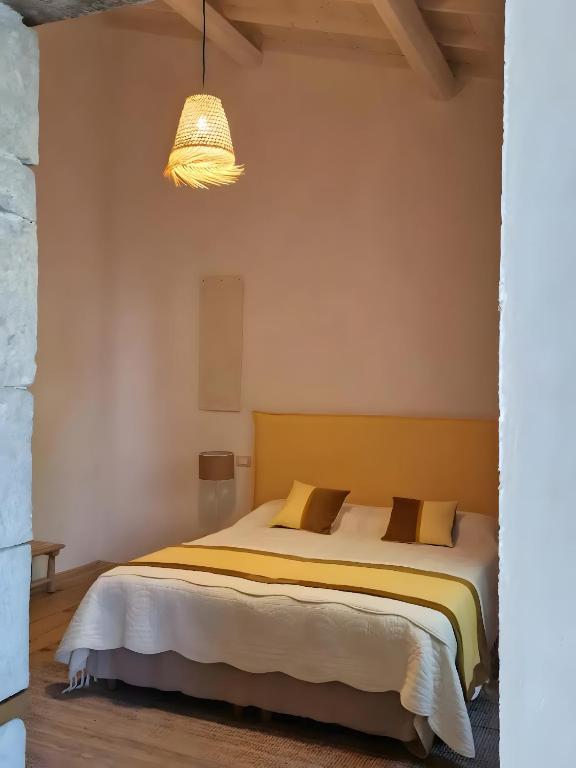 a bedroom with a bed with two pillows at Casa S'urtzula in Sini