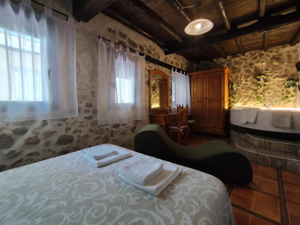 a bedroom with a bed with two towels on it at Valle del jerte el huerto del cura in Cabezuela del Valle