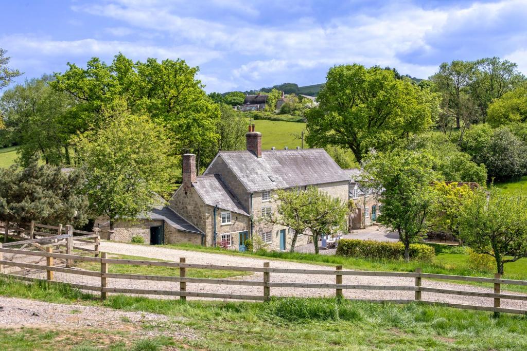 ein altes Haus auf einem Hügel mit einem Zaun in der Unterkunft French Mill in Shaftesbury