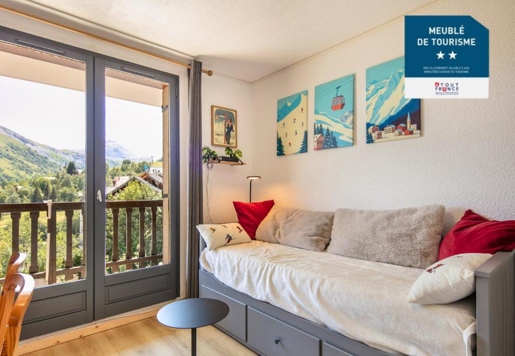 a living room with a couch and a balcony at Le Belvedere N11 - ST4 in Saint-Sorlin-dʼArves