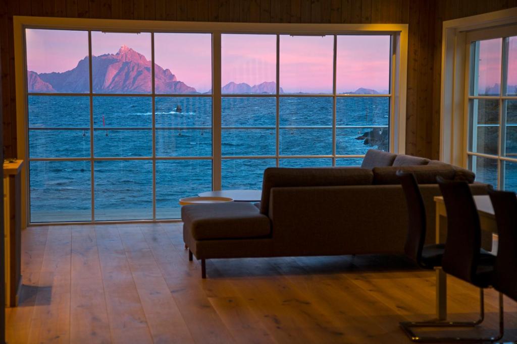 a living room with a couch and a view of the ocean at Lofoten Panorama in Stamsund