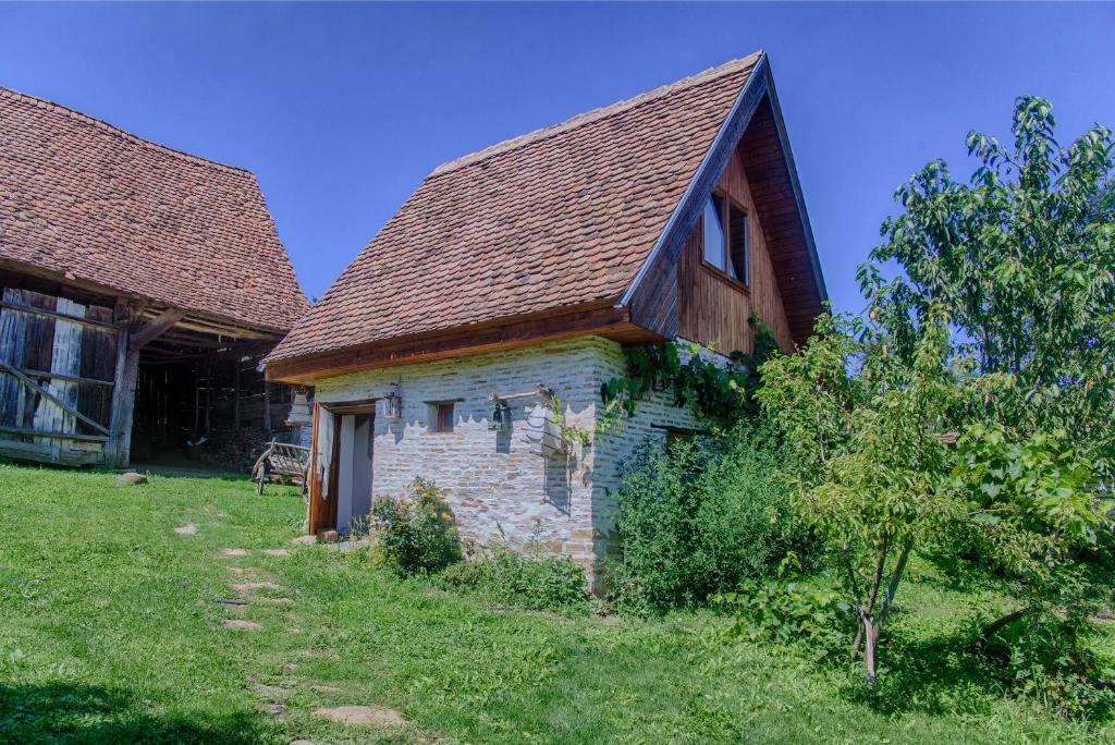 an old stone house with a brown roof at Dominic Boutique - Gardener's Cottage in Cloaşterf