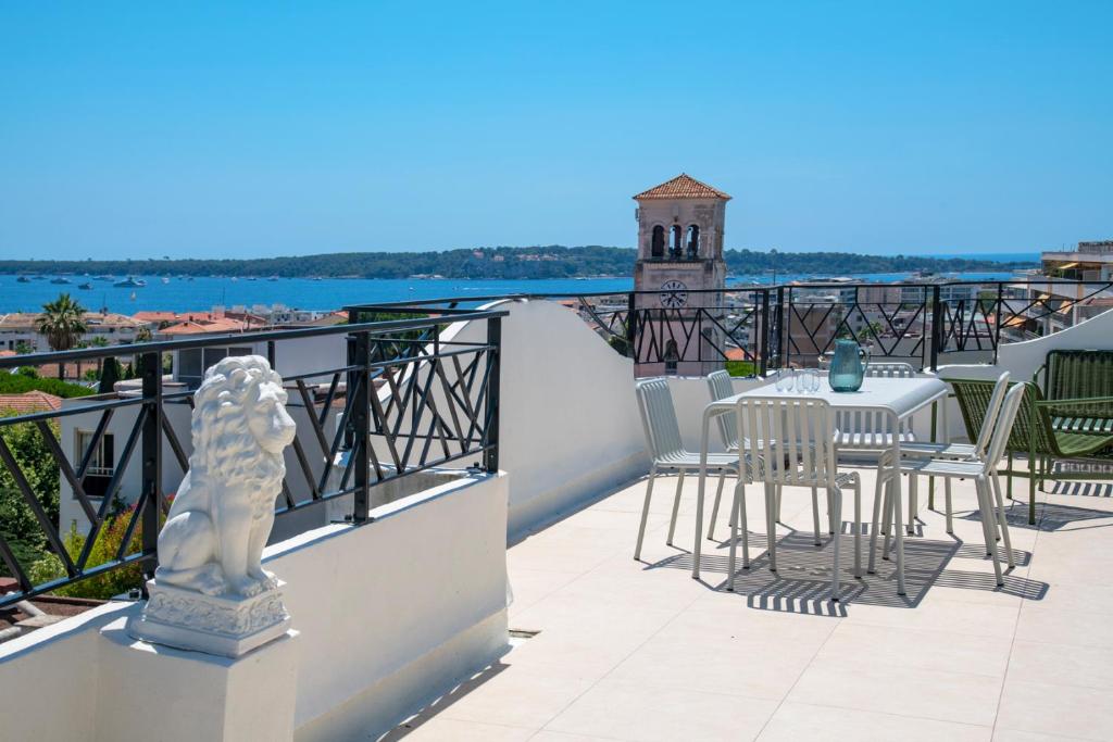 a patio with a table and chairs on a balcony at Les Pins in Cannes