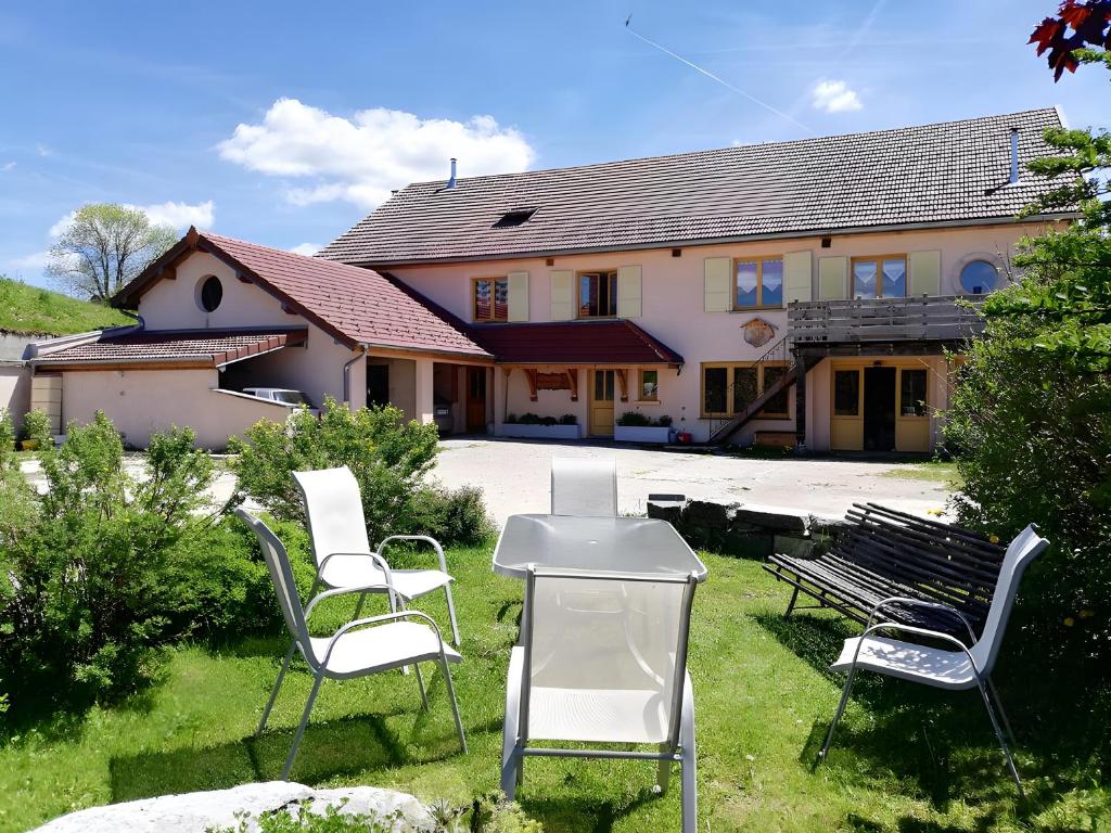a group of chairs sitting in front of a house at Gite Le Chant Du Coq in Bief-des-Maisons