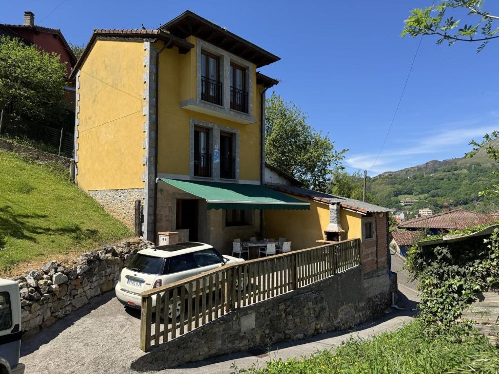 a yellow house with a car parked in front of it at Casa Marisa en Cangas de Onís VV-2929-AS in Cangas de Onís
