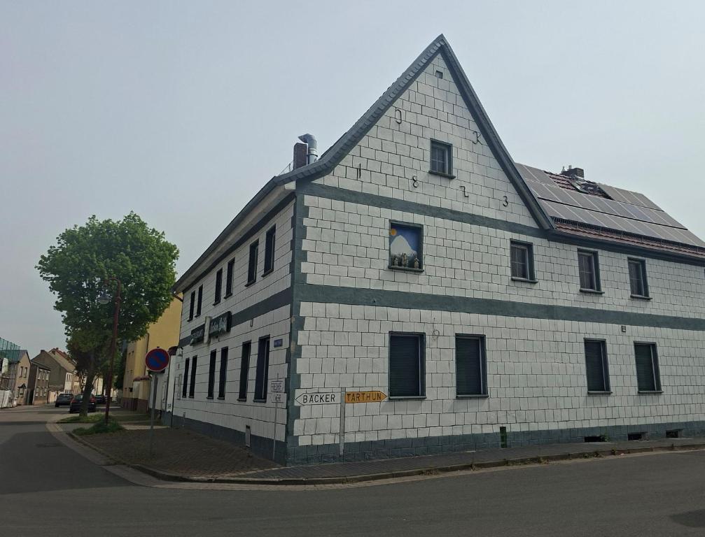 a white brick building with a gambrel roof at Unseburger Brauhaus - FW7 in Unseburg