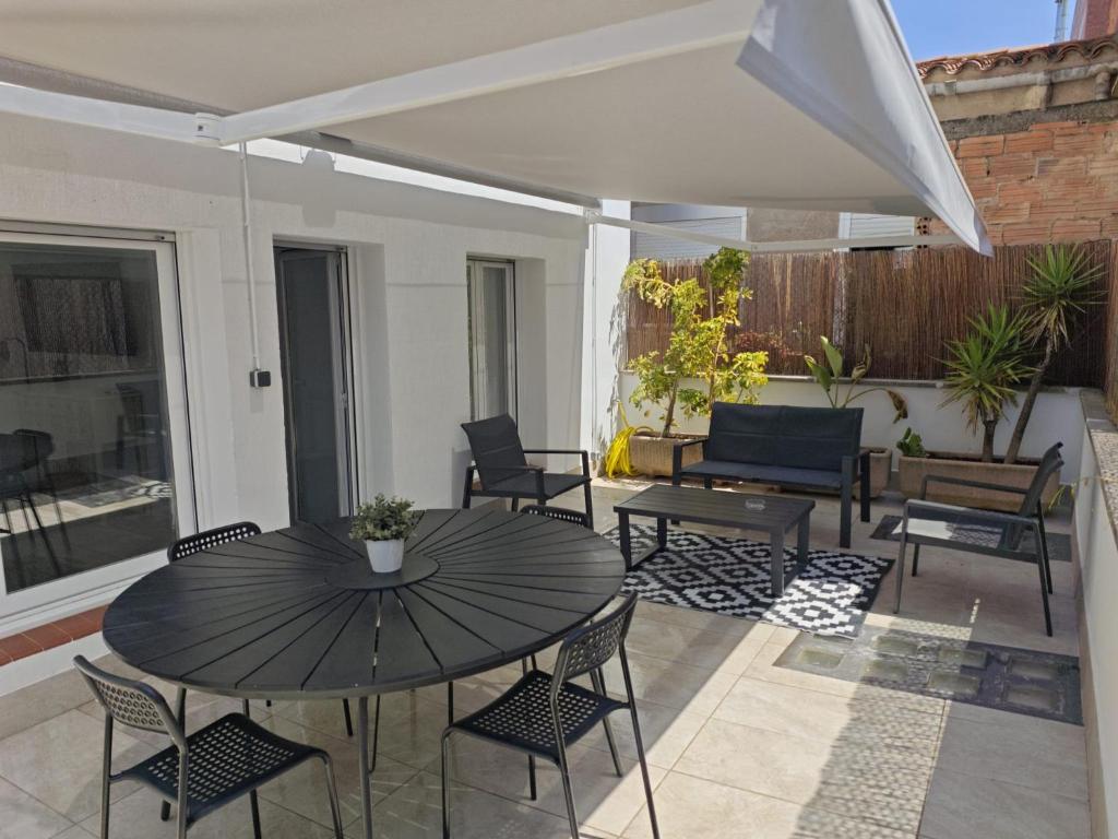 a patio with a black table and chairs at Apartaments IXA in Manresa