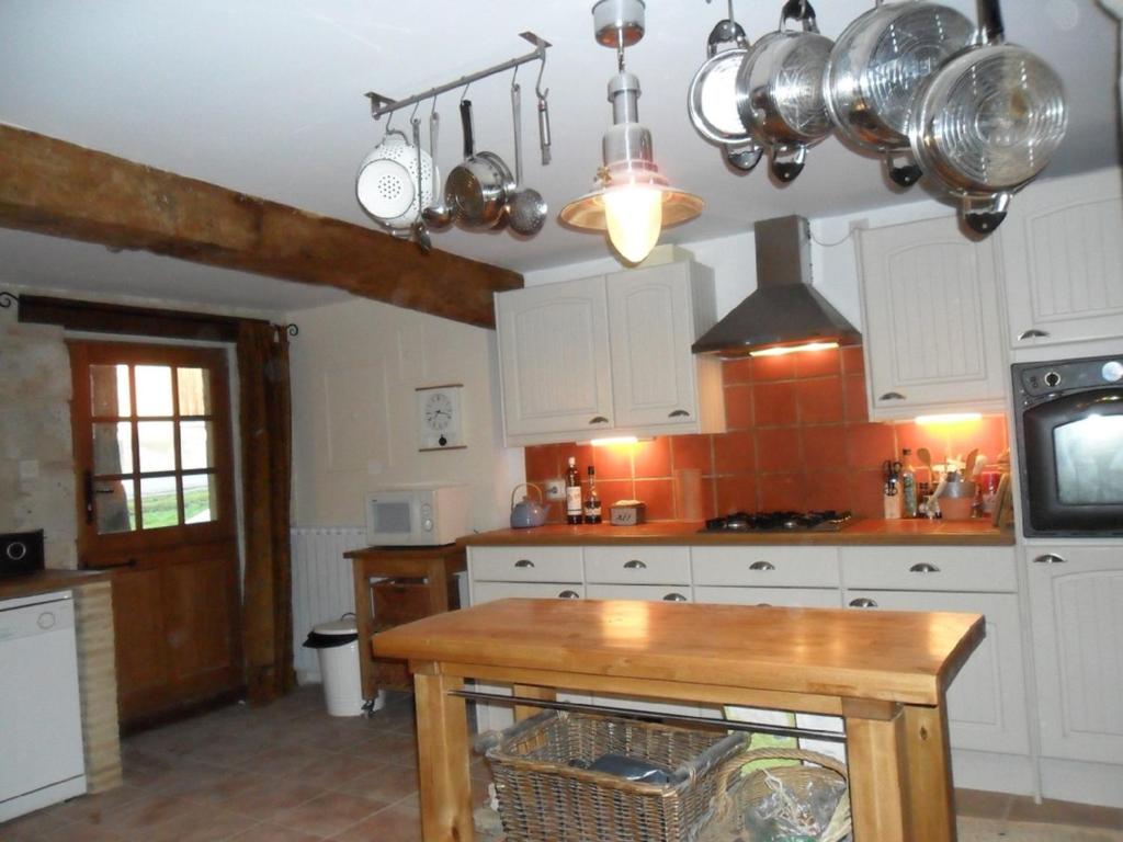a kitchen with white cabinets and a wooden table at '1786' au bourg in Mansonville