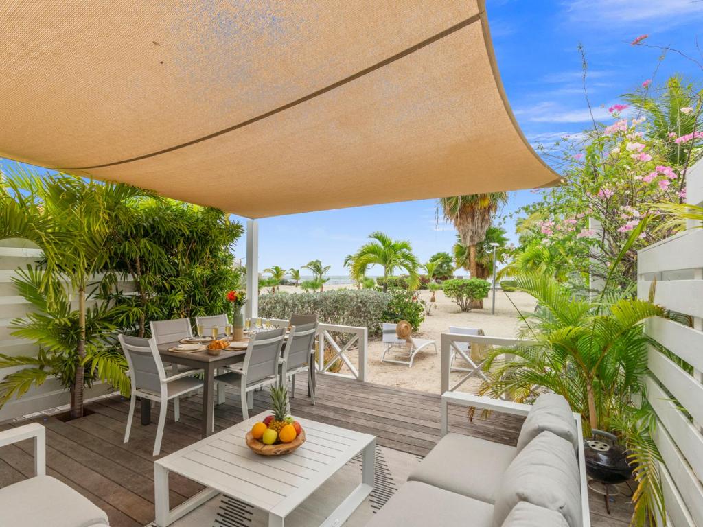 an outdoor patio with a table and chairs at Shell Beach Splendide 2 chambres sur la plage in Baie Nettle