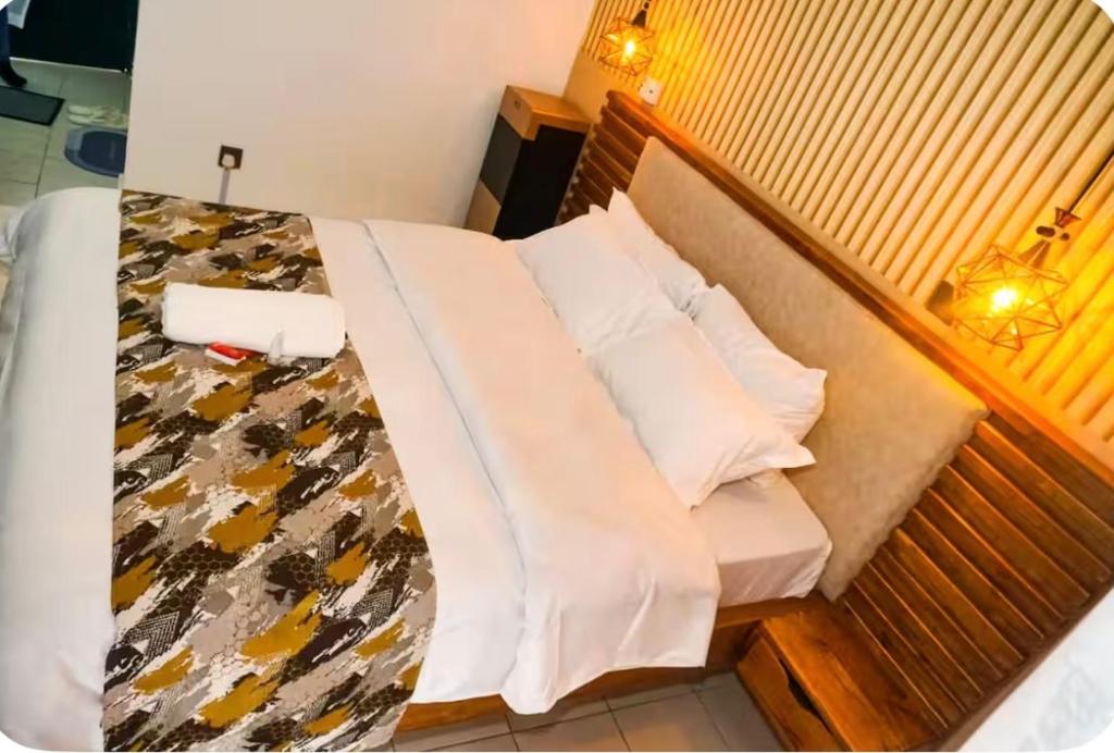 a bed in a small room with white pillows at Omtush Suites 002 in Marimbeti