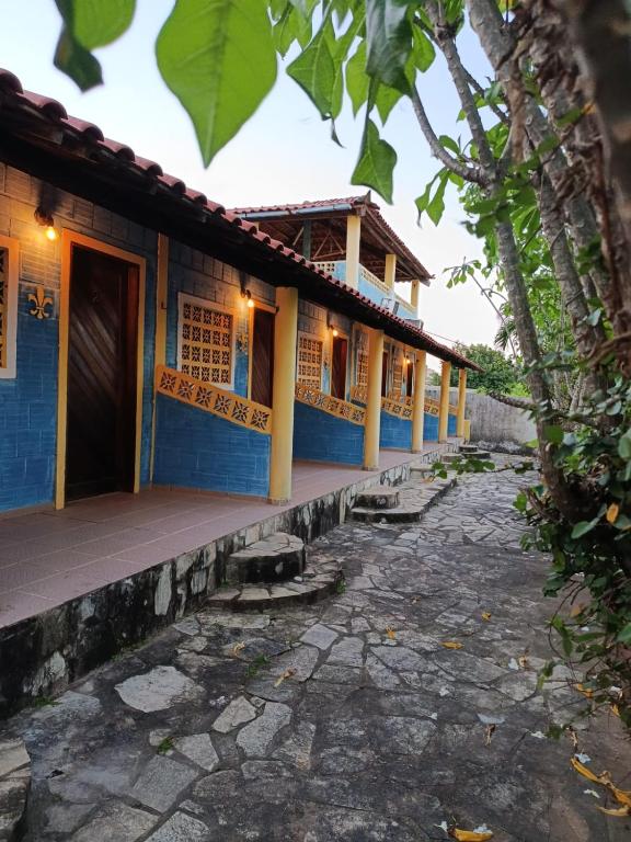a blue house with a pathway in front of it at Recanto Das Marés in Jacumã