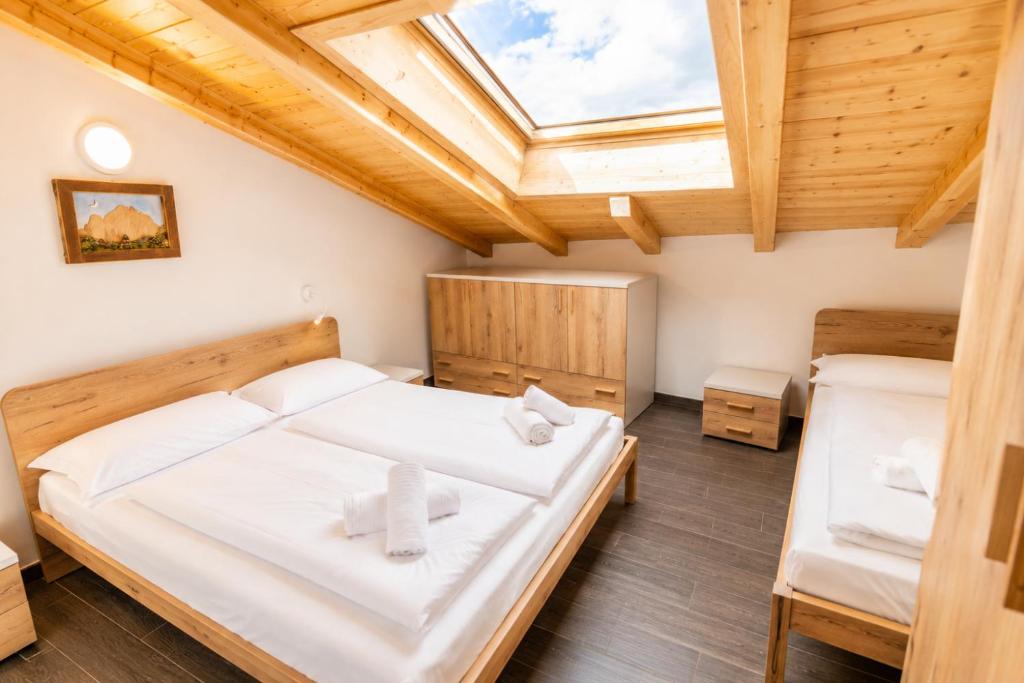 a bedroom with two beds and a skylight at Appartamento Rio Duron by AMA Val di Fassa in Campitello di Fassa