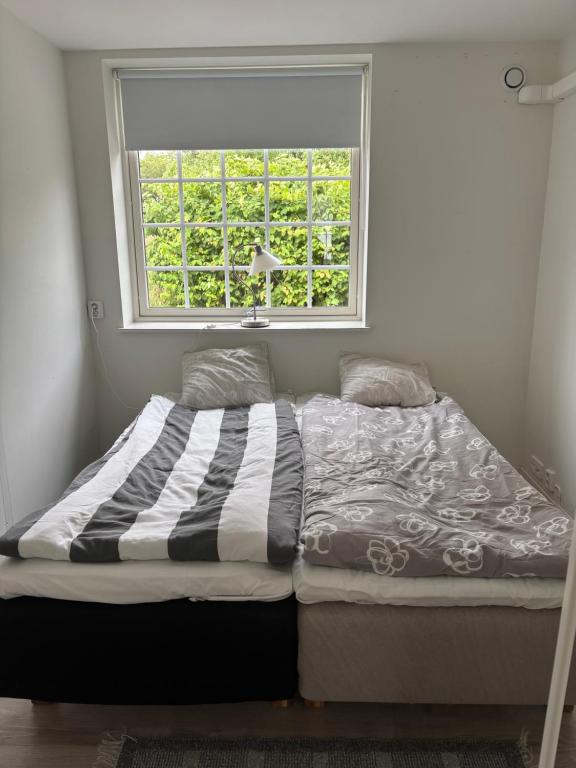 a bed in a room with a window at Smedjan affären in Varberg
