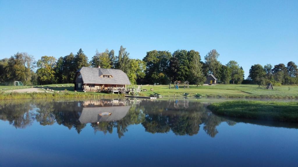 une grange assise à côté d'une grande étendue d'eau dans l'établissement Brīvdienu māja Polīši, à Kuldīga