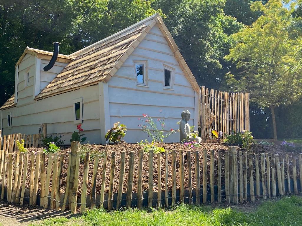 a small house behind a wooden fence at Cabane Forest in Villaines-la-Gonais
