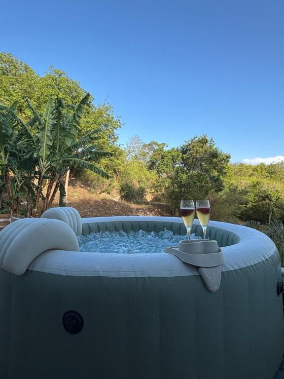 a hot tub with two glasses of wine at Le Clos de Bourgueil in Sainte-Anne